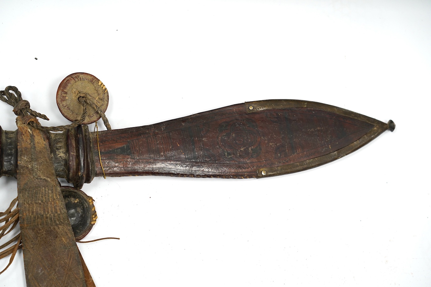 A late 19th century Nigerian Taboura from the Hausa People of Northern Nigeria, in leather scabbard, blade 59.5cm. Condition - good